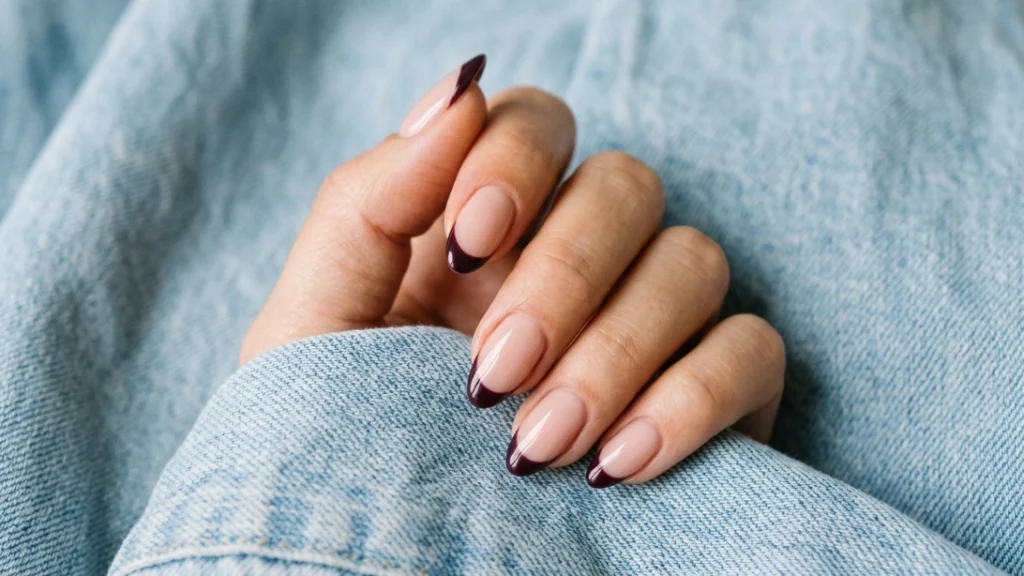 Dark plum French tip nails over a nude base