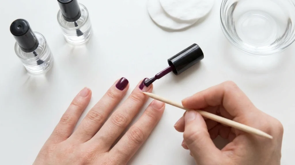 t-home application setup for dark plum nails with base coat and topcoat
