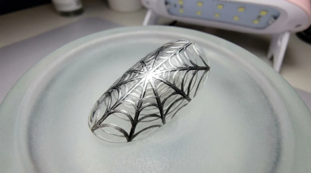 The finished silver-and-black web pattern, fully cured and ready for the blooming accents.