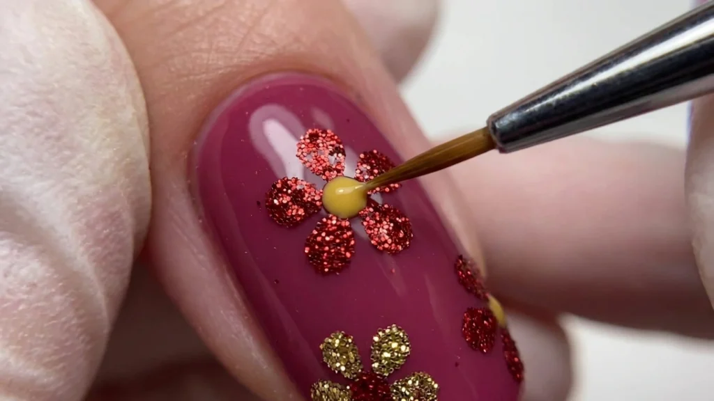 red floral glitter nail art - painting the flower center