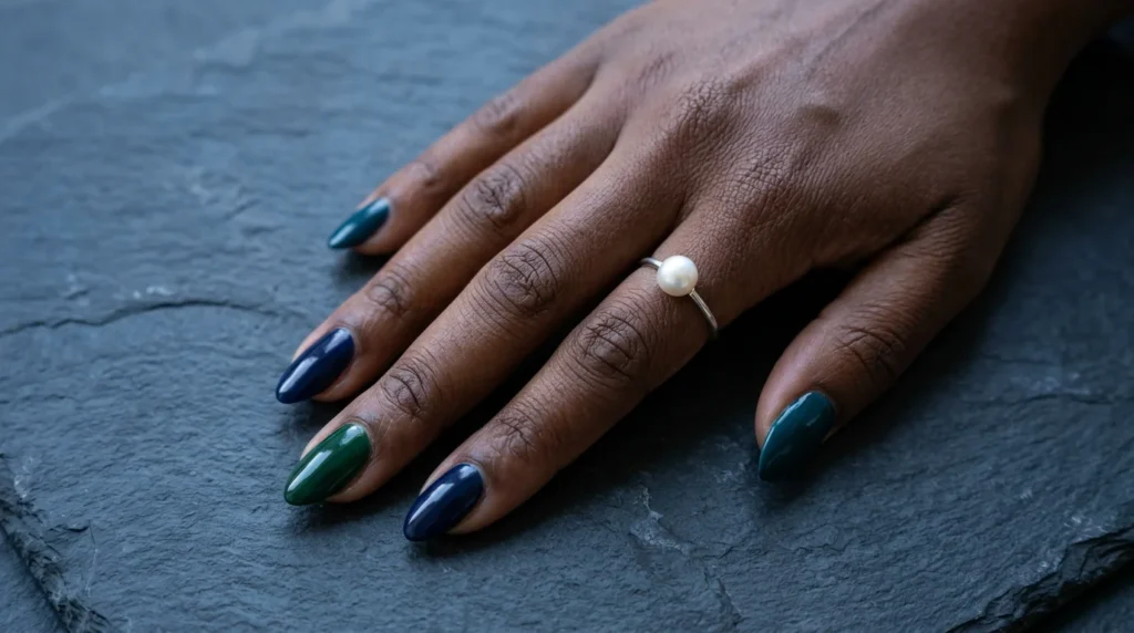 Midnight blue, emerald and deep teal nails with a glossy finish on dark skin