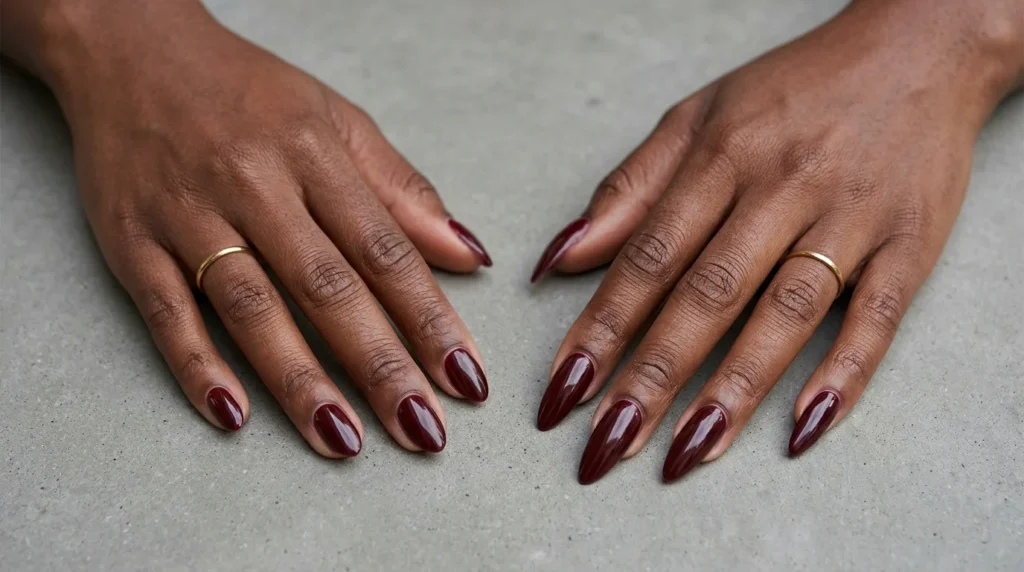 Short and long almond burgundy nails on dark skin