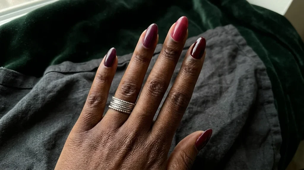 Plum, deep raspberry and burgundy nail polish compared on dark skin